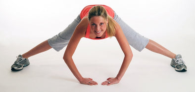 lady demonstrating a straddle hip hinge stretch from standing position